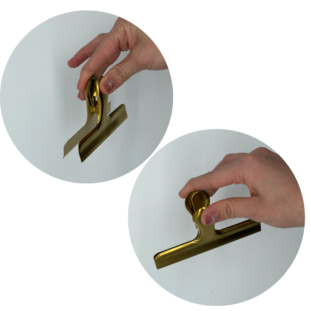 Two views of a gold stainless steel sheet music clip held by hand — showcasing the strong spring mechanism and durable grip for securely holding sheet music in place.