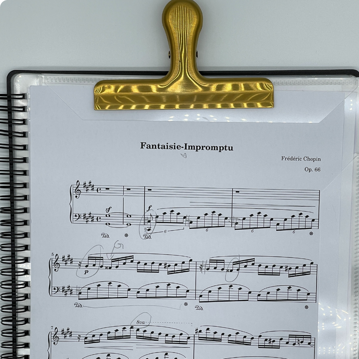 Gold stainless steel sheet music clip securely holding Fantaisie-Impromptu by Chopin on Piano Glory A4 Music Folder — elegant, durable clip designed to keep sheet music in place during piano practice or performance.